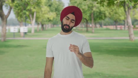 Hombre-Indio-Sikh-Enfermo-Que-Sufre-De-Dolor-De-Cuello-En-El-Parque