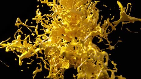 Golden-liquid-splash-in-3D-animation,-capturing-a-dynamic,-freeform-burst-with-glistening-reflections-on-a-black-backdrop