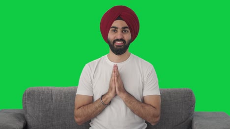 Fröhlicher-Sikh-Indianer,-Der-Namaste-Auf-Grünem-Bildschirm-Macht