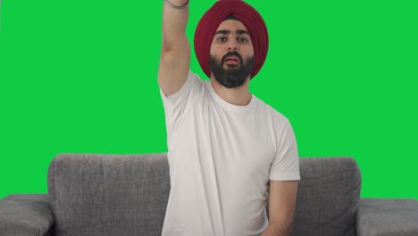 Wütender-Sikh-Indianer,-Der-Versucht,-Den-Grünen-Bildschirm-Der-TV-Fernbedienung-Zu-Reparieren