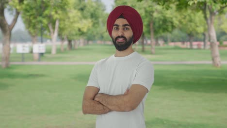 Porträt-Eines-Glücklichen-Sikh-Indianers,-Der-Mit-Gekreuzten-Händen-Im-Park-Steht