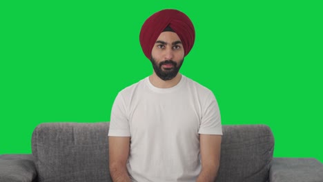 Ernsthafter-Sikh-Indianer,-Der-Mit-Jemandem-Auf-Grünem-Bildschirm-Spricht