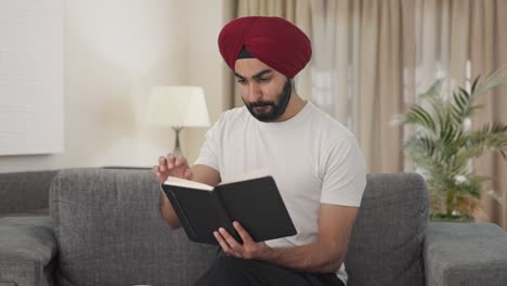 Happy-Sikh-man-reading-book-and-drinking-tea