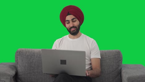 Fröhlicher-Indischer-Sikh-Manager,-Der-Einen-Videoanruf-Auf-Dem-Grünen-Bildschirm-Des-Laptops-Macht