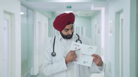 Médico-Indio-Sikh-Serio-Explicando-Informes-Médicos-Al-Paciente