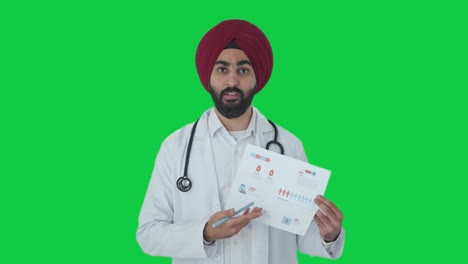 Médico-Indio-Sikh-Enojado-Explicando-Informes-Médicos-A-La-Pantalla-Verde-Del-Paciente