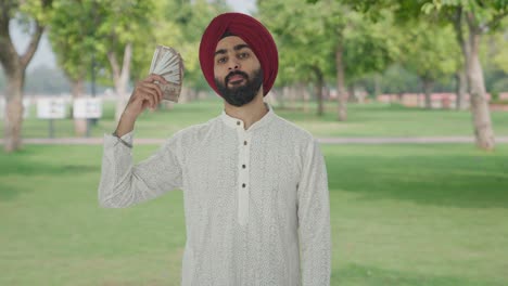 Hombre-Indio-Sikh-Egoísta-Usando-Dinero-Como-Ventilador-En-El-Parque