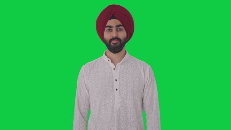 Fröhlicher-Sikh-Indianer,-Der-Auf-Grünem-Bildschirm-Lächelt
