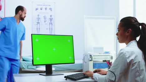 Doctor-using-computer-with-green-screen-display