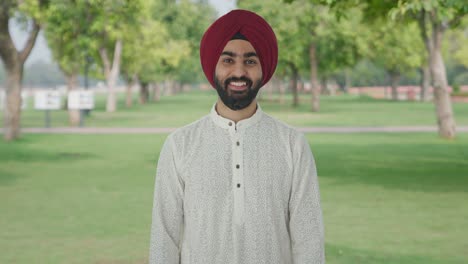 Glücklicher-Sikh-Indianer,-Der-Im-Park-In-Die-Kamera-Lächelt