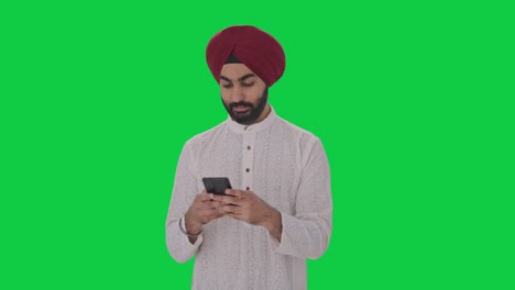 Glücklicher-Sikh-Indianer,-Der-Jemandem-Eine-SMS-Auf-Grünem-Bildschirm-Schreibt