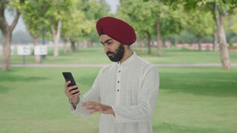 Hombre-Indio-Sikh-Usando-El-Teléfono-En-El-Parque