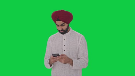 Angry-Sikh-Indian-man-texting-someone-Green-screen