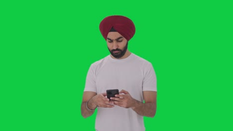 Sikh-Indian-man-texting-someone-Green-screen