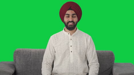 Fröhlicher-Sikh-Indianer,-Der-Auf-Grünem-Bildschirm-Lächelt