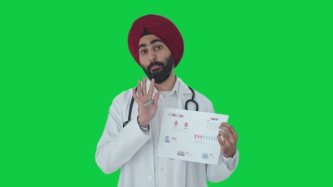 Feliz-Médico-Indio-Sikh-Explicando-Informes-Médicos-A-La-Pantalla-Verde-Del-Paciente