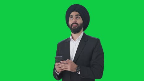 Glücklicher-Indischer-Sikh-Geschäftsmann,-Der-Jemandem-Eine-SMS-Auf-Grünem-Bildschirm-Schreibt
