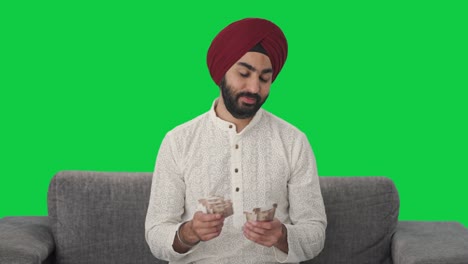 Happy-Sikh-Indian-man-counting-money-Green-screen
