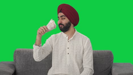 Egoistic-Sikh-Indian-man-using-money-as-fan-Green-screen