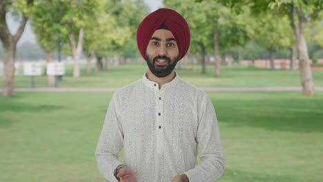 Ernsthafter-Sikh-Indianer,-Der-Im-Park-Mit-Der-Kamera-Spricht
