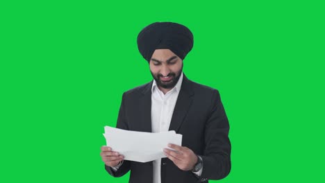 Glücklicher-Indischer-Sikh-Geschäftsmann,-Der-Unternehmensberichte-Auf-Grünem-Bildschirm-Liest