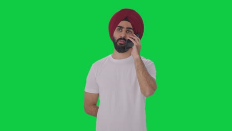 Sikh-Indianer,-Der-Auf-Dem-Grünen-Bildschirm-Des-Telefons-Spricht
