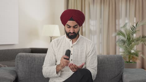 Frustrierter-Sikh-Indianer,-Der-Versucht,-Die-TV-Fernbedienung-Zu-Reparieren