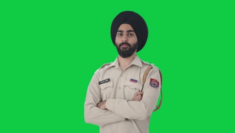 Porträt-Eines-Selbstbewussten-Sikh-Polizisten,-Der-Mit-Gekreuzten-Händen-Auf-Grünem-Bildschirm-Steht