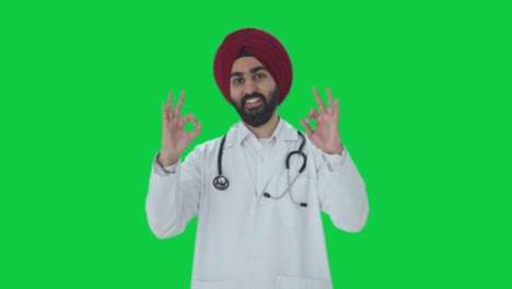 Fröhlicher-Indischer-Sikh-Arzt,-Der-Einen-Grünen-Bildschirm-Zeigt