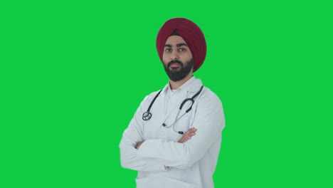 Porträt-Eines-Selbstbewussten-Indischen-Sikh-Arzts,-Der-Mit-Gekreuzten-Händen-Auf-Grünem-Bildschirm-Steht
