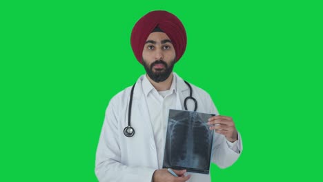 Serious-Sikh-Indian-doctor-explaining-X-ray-report-to-patient-Green-screen
