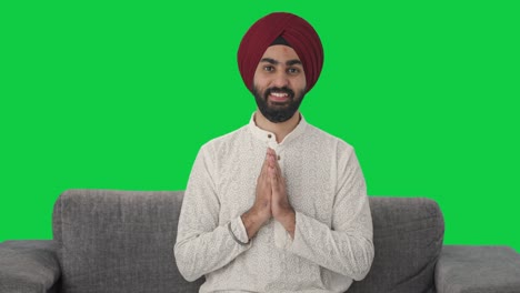 Fröhlicher-Sikh-Indianer,-Der-Namaste-Auf-Grünem-Bildschirm-Macht