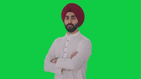 Porträt-Eines-Selbstbewussten-Indischen-Sikh-Mannes,-Der-Mit-Gekreuzten-Händen-Auf-Grünem-Bildschirm-Steht
