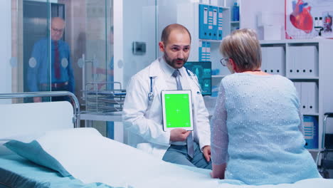 Médico-Con-Tableta-De-Pantalla-Verde-Frente-A-Paciente-Anciano