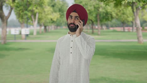 Happy-Sikh-Indian-man-talking-on-phone-in-park