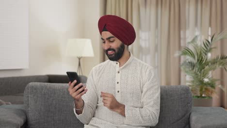 Glücklicher-Sikh-Indianer,-Der-Das-Telefon-Scrollt