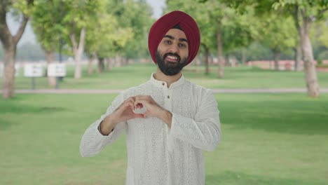 Fröhlicher-Sikh-Indianer-Zeigt-Herzschild-Im-Park