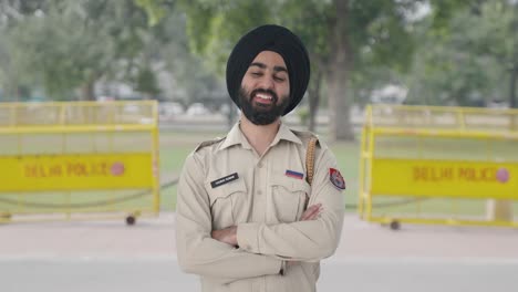 Happy-Sikh-Indian-police-man-standing-crossed-hands