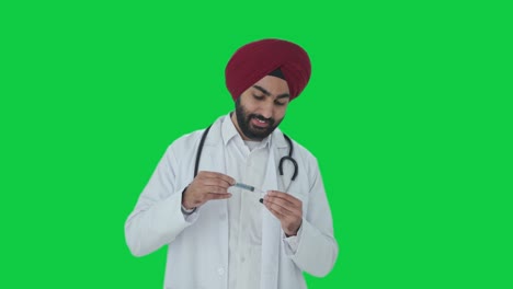 Glücklicher-Indischer-Sikh-Arzt,-Der-Einen-Injektions-Greenscreen-Füllt