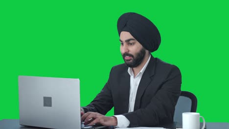 Happy-Sikh-Indian-businessman-working-on-Laptop-Green-screen