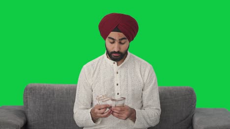 Sad-Indian-man-counting-money-Green-screen