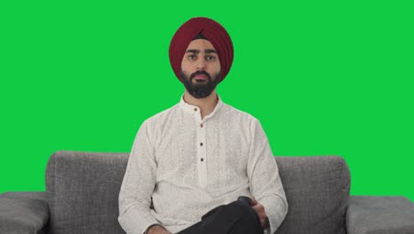 Ernsthafter-Sikh-Indianer,-Der-Fernsieht,-Grünen-Bildschirm