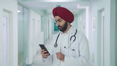 Ernsthafter-Indischer-Sikh-Arzt,-Der-Das-Telefon-Scrollt