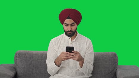 Sikh-Indianer,-Der-Jemandem-Eine-Nachricht-Auf-Grünem-Bildschirm-Sendet