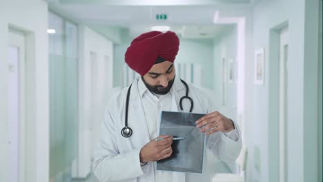 Feliz-Médico-Indio-Sikh-Explicando-El-Informe-De-Rayos-X-Al-Paciente