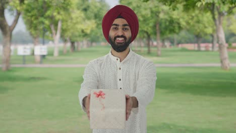 Glücklicher-Sikh-Indianer,-Der-Im-Park-Ein-Geschenk-Macht