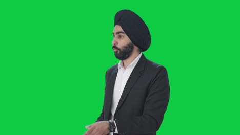 Serious-Sikh-Indian-businessman-talking-to-employees-Green-screen