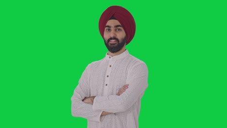 Porträt-Eines-Glücklichen-Sikh-Indianers,-Der-Mit-Gekreuzten-Händen-Auf-Grünem-Bildschirm-Steht