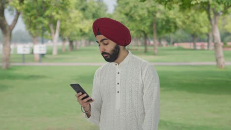 Lazy-Sikh-Indian-man-using-phone-in-park