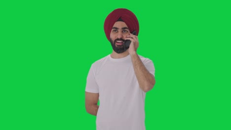 Fröhlicher-Sikh-Indianer,-Der-Am-Telefon-Spricht-Und-Auf-Dem-Grünen-Bildschirm-Lächelt